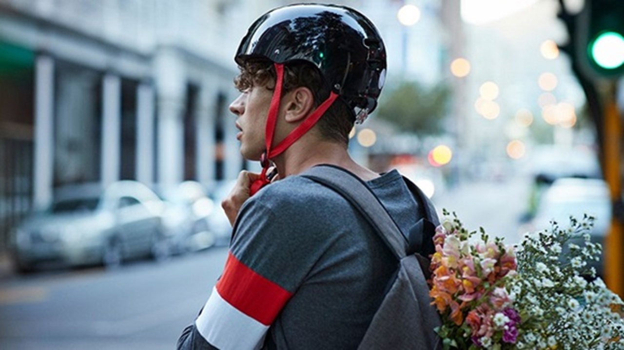 A man wearing a cycling helmet looking out onto a street